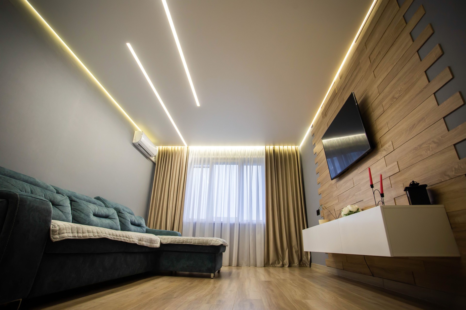 Modern interior in the living room with wooden laminate flooring, wall-hung cabinets and LCD TV. Stretch diode ceiling around the perimeter. Copy space for text, conditioner